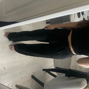 Svarta vida byxor med resårmidja - Säljer ett par svarta byxor med avslappnad passform och resår i midjan. Byxorna har raka, vida ben och har linne liknande material. Vid byxkanten är de lite slitna skriv för mer detaljerad bild på slitaget. 