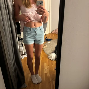 Ljusblå highwaist jeansshorts -  Ljusblå jeansshorts från H&M med hög midja och fyra fickor. Shortsen har uppvikta benslut och bälteshällor, perfekta för sommardagar. Mjukt denimtyg som är skönt att bära och passar till allt. Säljer pga att de inte blivit använda på flera år, använda väldigt få gånger