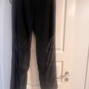 Svarta meshbyxor från BikBok - Säljer ett par svarta meshbyxor från BikBok i storlek L. Byxorna är helt genomskinliga och har en loose passform med raka ben och har en shorts under som sitter fast i den.
