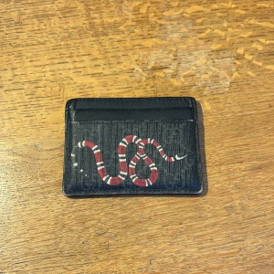 Gucci snake card holder - Säljer min Gucci korthållare som inte används längre. Den har varit väl använd vilket syns men just nu samlar den bara damm. Finns tyvärr inget kvitto kvar utan bara dustbagen.