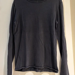 Mörkblå långärmad tröja från Crocker - En basic mörkblå långärmad tröja från Crocker i storlek S. Tröjan har en enkel design med rund halsringning och mjukt material som känns skönt mot huden. Perfekt att styla med jeans eller under en jacka när det är kyligt ute.