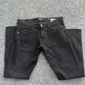 Replay Anbass - Svarta jeans från Replay, modell Anbass. Klassisk femficksdesign med snygga detaljer på bakfickorna och Replay-logga. Jeansen har normal passform och är tillverkade i mjukt bomullsmaterial med stretch för extra komfort.