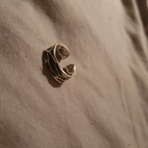 Silvrig chunky ring med organiskt mönster - Cool silvrig ring med chunky känsla och ett organiskt, nästan grenliknande mönster. Ringen är öppen baktill vilket gör den justerbar och passar flera storlekar. Perfekt för dig som gillar unika accessoarer med lite edge.