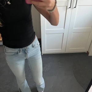 Ljusblå slit flare jeans Bailey 152 - Säljer ett par ljusblå slit flare jeans från Cubus i storlek 152. Jeansen har snygga slitsar nertill, klassisk femficksmodell och låg midja. De är tillverkade i mjukt bomull och polyester och har en riktigt trendig flare passform. Midja: ca 32 cm (stretchig) Innerbenslängd ca 70cm