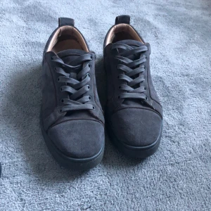 Svarta skor med röd sula från Christian Louboutin - Säljer ett par ikoniska svarta skor från Christian Louboutin med den klassiska röda sulan. Perfekta för dig som vill sticka ut med en lyxig och elegant touch.