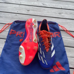 Adidas Predator elite - Säljer ett par Adidas Predator fotbollsskor i blått med vita detaljer och röda snören. Skorna har en smidig syntetöverdel och mönstrad sula för grymt grepp på planen. Perfekta för dig som vill sticka ut med stil och prestanda på matchen. Nypris runt 3000