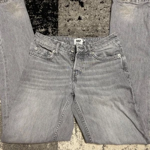 Grå straight jeans från 157 Icon - Snygga grå jeans från 157 Icon med klassisk femficksdesign och knäppning med tre silverfärgade knappar. Jeansen har raka ben och en avslappnad passform. Perfekta för dig som gillar en stilren och enkel look.