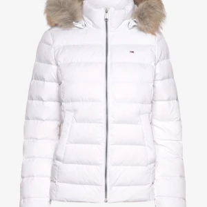 Vit dunjacka från Tommy Hilfiger - Snygg vit dunjacka från Tommy Hilfiger med pälskantad huva och quiltad design. Jackan har dragkedja framtill, två fickor och diskret logga på bröstet. Perfekt för kalla dagar när du vill hålla stilen och värmen. Den har några små defekter men inget jag tycker syns 💞 Nypris ca. 2600 tror jag!