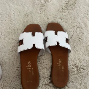 Vita slip-in sandaler - Så fina, köpa i en skobutik i Spanien. Ändats använda där vid 4 tillfällen. Märket är Rebecca hope.