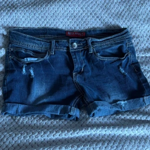 Mörkblå jeansshorts Red Rivet - Snygga mörkblå jeansshorts från Red Rivet med slitna detaljer och uppvikta benslut. Klassisk femficksmodell med kontrastsömmar och snygga bakfickor med broderade mönster. Helt nya och oanvända. Nypris 300 kr💕