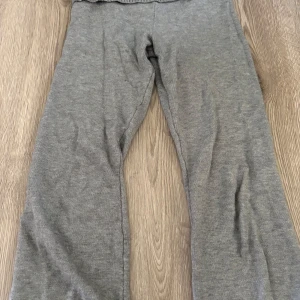 Grå mjukisbyxor från Gina Tricot - Grå mjukisbyxor från Gina Tricot med bred ribbad midja. Byxorna är i mjukt material.