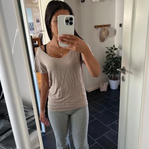 Beige t-shirt med lös passform XS - Enkel beige t-shirt från 157 i storlek XS. Modellen har lös passform, korta ärmar och rundad halsringning. Perfekt för en chill och avslappnad stil. Tunt och mjukt material som känns skönt mot huden.