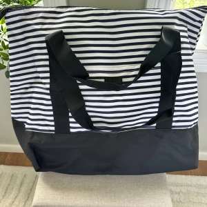 Strandväska (SOC) - Denna väska är i nyskick och har bland annat praktiska fack och slitstarka handtag. Perfekt till stranden nu i sommar. 