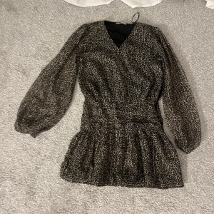 Leopard klänning - Leopard klänning med volanger nedtill. Superfint material och fin på! Använd en gång🫶🏻passar mest XS men också S. Köpt på Gina Young