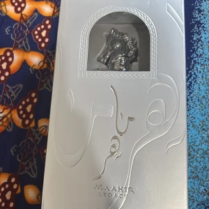 Maahir Legacy Eau de Parfum - Maahir Legacy Eau de Parfum i en elegant silverfärgad förpackning med hästhuvud i metall på flaskan. Parfymen har en lyxig och modern design, perfekt för dig som gillar exklusiva dofter och snygga detaljer.