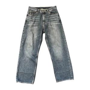 Blå jeansbyxor från Dr. Denim - Säljer ett par klassiska blå jeansbyxor från Dr. Denim, modell Omar. Byxorna har raka, vida ben. De är tillverkade i bomull och har en avslappnad passform med normal midja. Perfekta för en avslappnad stil.