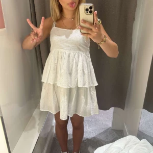 Vit kortklänning med volang - Söt vit miniklänning med volang och tunna axelband. Den ör naturvit med lite guldiga små detaljer över hela klänningen!!💞endast använd en gång!