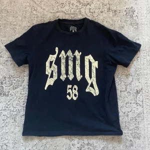 SMG 58 tshirt - En svart smg 58 tshirt. Ganska boxig passform så passar ganska bra som M. Trycket har flagnat en del men annars har den inga defekter.