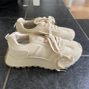 Beige sneakers från QAVING - Super snygga och sköna skor, helt sprillans nya aldrig använda, säljs pågrund av fel storlek. 
