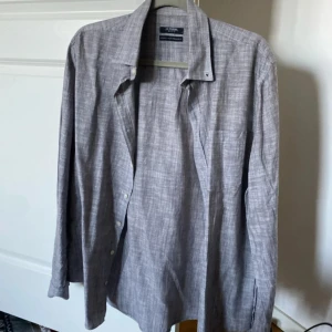 Grå skjorta från LC Waikiki - Säljer en stilren grå skjorta från LC Waikiki i regular fit. Skjortan har klassisk krage, knäppning framtill och lång ärm. Perfekt för dig som gillar en enkel och tidlös look.