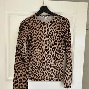 Leopardmönstrad långärmad tröja - Säljer en snygg långärmad tröja med leopardmönster. Tröjan har rund halsringning och är i ett mjukt, stretchigt material. Perfekt för dig som vill sticka ut lite extra. Storlek M men passar mig som är S. Använt 1 gång.
