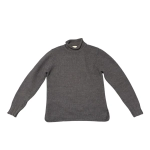 Grå stickad polotröja från Filippa K - Mörkgrå stickad polotröja från Filippa K. Klassisk modell med lång ärm och hög polokrage. 