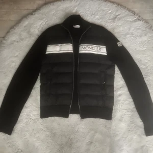 Moncler cardigan - Snygg navy blue cardigan jacka från Moncler med silver dragkedja och vit logotext på bröstet. Sällysn design och väldigt skön material, perfekt för blåsiga dagar. Skick 8/10, hör av vid intresse😃