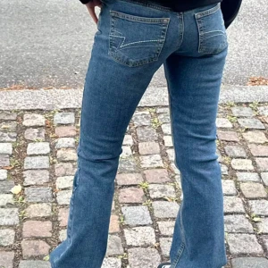 Bootcut jeans med fin detalj på fickorna  - Säljer ett par klassiska blå jeans med fin detalj på bak fickorna. Använd fåtal gånger. Bootcut låg midja storlek xs. Köpta på junkyard för 600kr💕