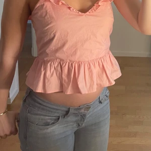 Rosa volangtopp med öppen rygg - Söt rosa topp med volang!💕Toppen är ärmlös och har en öppen rygg med knytband. Lite liten i storleken.