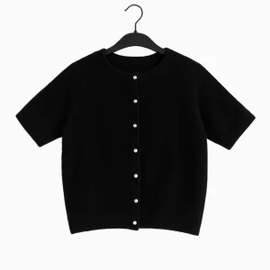 Svart kortärmad kofta med pärlknappar - Stilren svart kofta med korta ärmar och pärlknappar framtill. Perfekt för att lyfta en enkel outfit med en elegant touch. Klassisk rund halsringning och rak passform. Använd ca 1-2 gånger. Ny pris 250kr