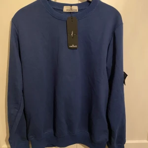 Blå tröja från Stone Island - Säljer en stilren blå tröja från Stone Island. Tröjan är väldigt lite använd. Säljer pga den är för liten. Hör av er vid funderingar. Priset kan diskuteras vid snabb affär