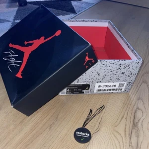 Nike Air Jordan 4s Infrared - Snygga Nike Air Jordans i en cool grå färg med röda detaljer. Skorna har en klassisk design med snörning och en bekväm passform. Perfekta för dig som vill ha en stilren look med en touch av färg.