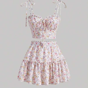 Blommigt set med topp och kjol - Säljer ett sött blommigt set med en  topp och matchande kjol. Knytning av axelband. Perfekt till sommaren!