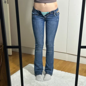 Lågmidjade bootcut jeans lowwaist utsvängda jeans vintage  - Superfina jeans. Bra skick endast avskavda på de bruna ställena. Storlek xs. Kan även passa xxs. Innerbenslängd:77 midjemått:30 stretch till 36. Köp sker via köp nu, jag postar inom 24h. Kvar tills markerad såld 