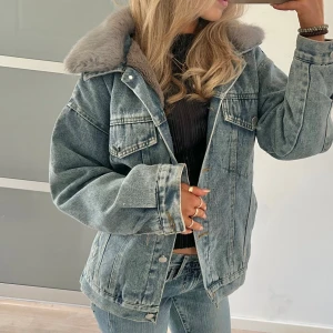 Jeansjacka med foder - Säljer en snygg jeansjacka med mjukt pälsfoder och krage. Jackan har en klassisk blå denimlook med knappar framtill och två bröstfickor. Perfekt nu till lite kyligare dagar om våren