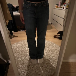 Blå jeans - Snygga blå jeans med klassisk rak passform och femficksdesign. Perfekta för en avslappnad stil. De har en knappgylf och är tillverkade i ett slitstarkt denimtyg.