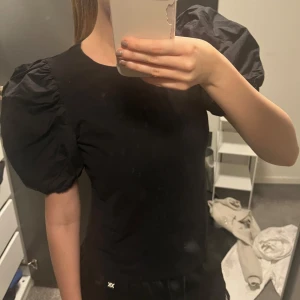 Svart topp med puffärmar - Jättefin svart T-shirt med puffärmar från hm 