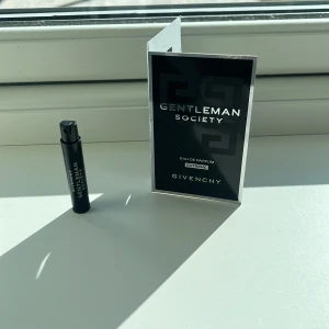 Gentleman Society Eau de Parfum från Givenchy - Upptäck Gentleman Society Eau de Parfum från Givenchy i en smidig provflaska. Denna doft kombinerar eleganta och beroendeframkallande tränoter med en unik signatur av narcissusblomma och salvia. Perfekt för den moderna gentlemannen som vill utstråla stil och självsäkerhet.