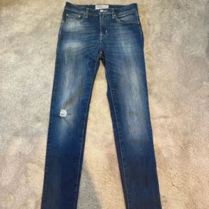 Blå jeans från Jacob Cohen - Snygga blå jeans från Jacob Cohen med en klassisk femficksdesign. De har en lätt slitning och en liten reva på ena benet för en trendig look. Perfekta för en avslappnad stil. Användna 3 gånger. Storlek 27 men sitter rätt mycket större. Plick skär bort delar av bilden så kom dm för bättre bilder💯                                                                                              Mvh Doré.reselll