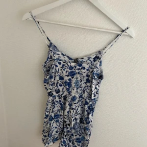 Blommig shorts byxdress  från H&M Divided - Säljer en söt byxdress från H&M Divided i storlek XS. Aldrig använt 