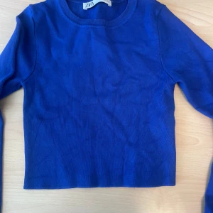 Blå ribbad tröja från Zara - Säljer en snygg blå ribbad tröja från Zara. Tröjan har en enkel design med långa ärmar och rund halsringning. Perfekt för en stilren look.
