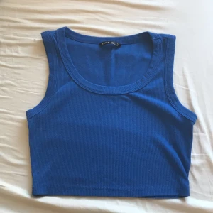 Blå ribbad linnetopp från Shein - Säljer en snygg blå ribbad linnetopp från Shein. Toppen är ärmlös och har en rund halsringning, perfekt för varma dagar. Den är i storlek S och passar utmärkt till både jeans och kjol. Perfekt för en avslappnad stil!💞