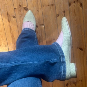 Ljusgröna pumps med struktur - Säljer ett par ljusgröna pumps från By med låg klack och spetsig tå. Skorna har en snygg strukturerad yta som ger dem ett unikt utseende. Perfekta för dig som vill ha något stilrent men ändå annorlunda.