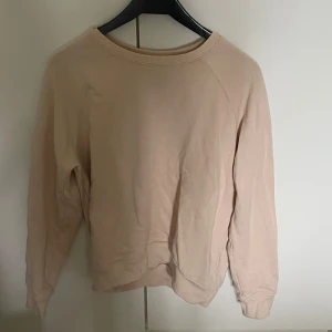 Beige sweatshirt - En enkel och stilren beige sweatshirt med rund halsringning och långa ärmar. Perfekt för en avslappnad look och lätt att matcha med andra plagg.