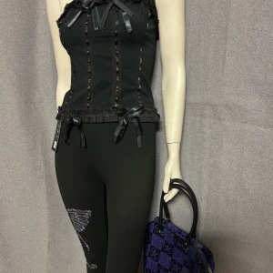 Lila och svart handväska med pentagram - Cool handväska i lila och svart med pentagram-mönster. Väskan har svarta handtag och dragkedja upptill. Perfekt för dig som gillar alternativ stil och vill sticka ut.