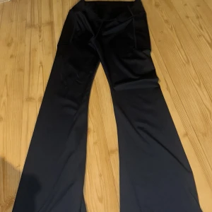 Svarta vida byxor med hög midja - Säljer ett par svarta byxor med hög midja och vida ben. Byxorna har en stilren look och är perfekta för dig som gillar en relaxed men trendig stil. Passar till många olika outfits och är riktigt bekväma.