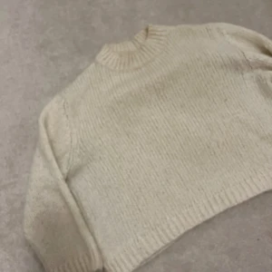 Vit stickad  tröja från Zara - Säljer en vit stickad  tröja från Zara. Tröjan har lång ärm, ribbad struktur och rund halsringning. Perfekt för lager-på-lager och enkel att matcha med olika outfits.