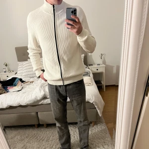 Stickad zip tröja från Tommy Hilfiger - Säljer denna snygga zip tröja från Tommy Hilfiger. Den är i väldigt bra skick och är endast använd 2-3 gånger då den är lite för stor för mig.(jag är 185) Nypris är 1500kr, säljer för 500kr 