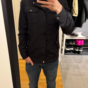  J.Lindeberg field jacka S - Säljer en svart jacka från J.Lindeberg som är perfekt till vår sommar när det är lita kallare och man vill värma sig lite så funkar denna jacka perfekt. Inga märken eller håll på den. 