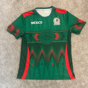 Mexiko fotbollströja - Säljer en grön Mexiko fotbollströja med aztekiskt inspirerat mönster.